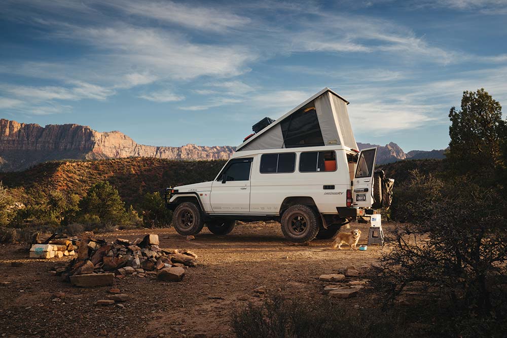 The Troopy parked at a dirt campsite with the top up and back door open while traveling in the Grand Canyon.