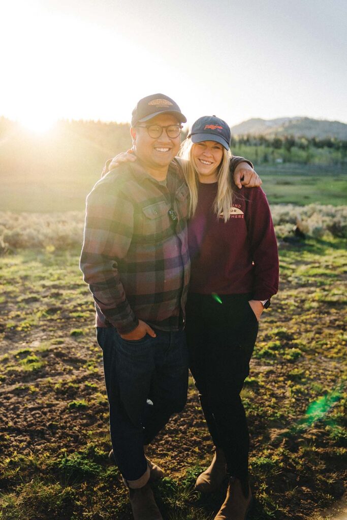 The couple poses arm in arm, smiling. 