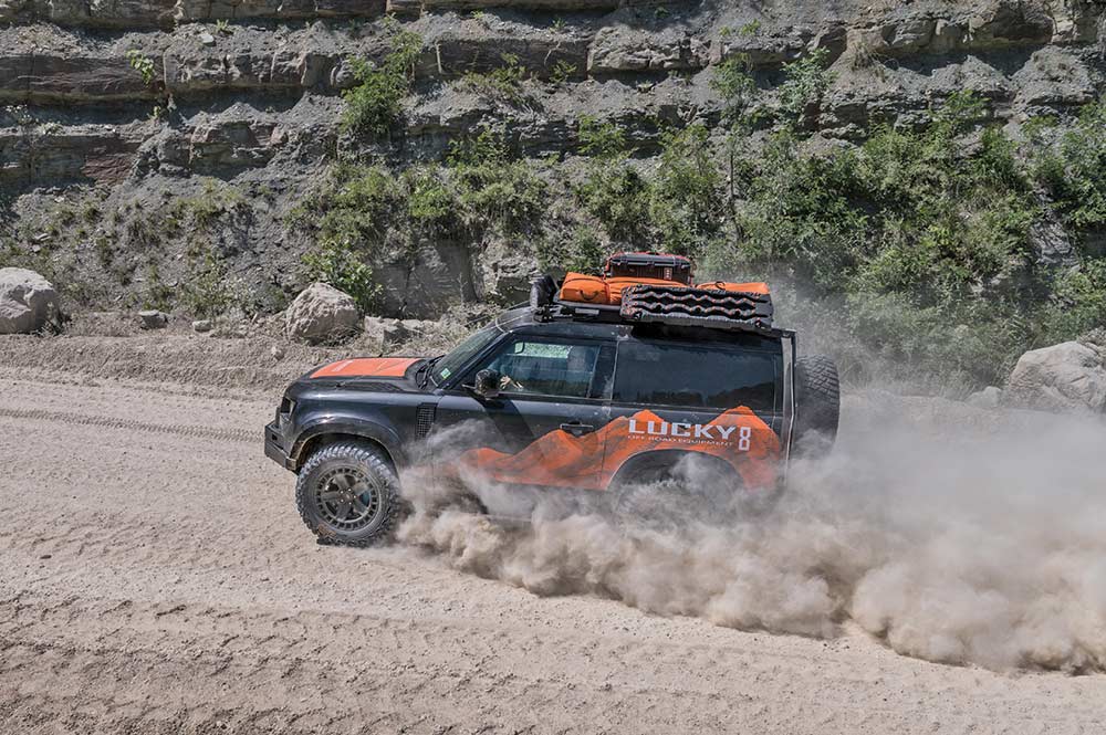 Lucky 8 Land Rover drives a dirt road