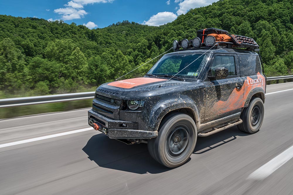 Land Rover Defender drives on the road 