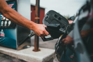 Someone puts gas in their car while overlanding.