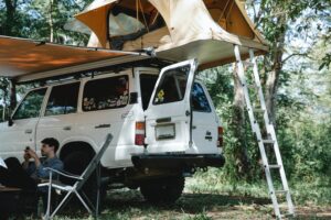 An overlander rests under a canopy at his campsite.