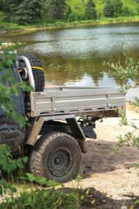 Back of truck with rear tire by a river. 