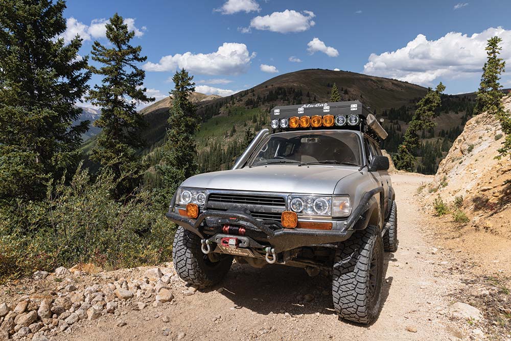 The Land Cruiser drives up a sandy mountain trail.