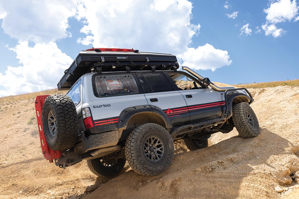 Alpha Equipt Halo wheels wrapped in Toyo Tires Open Country R/T Trail tires get this Land Cruiser up a sandy slope.