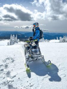 Rider overlooks the mountains on a snowmobile