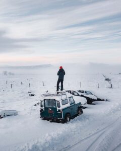 snowbound cars on side of road 