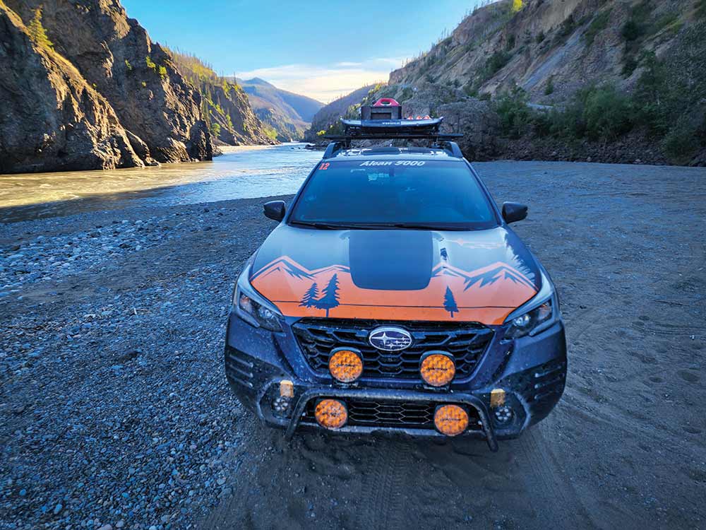 Parked in a shady gulch, the orange badging and lights on the Subaru stand out.