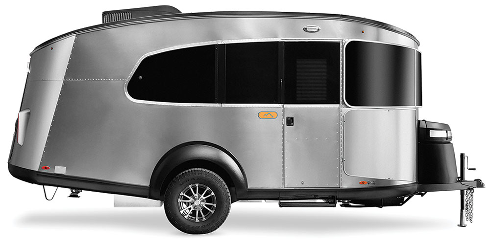 The aluminum Basecamp trailer has wrap around windows and a streamlined design.