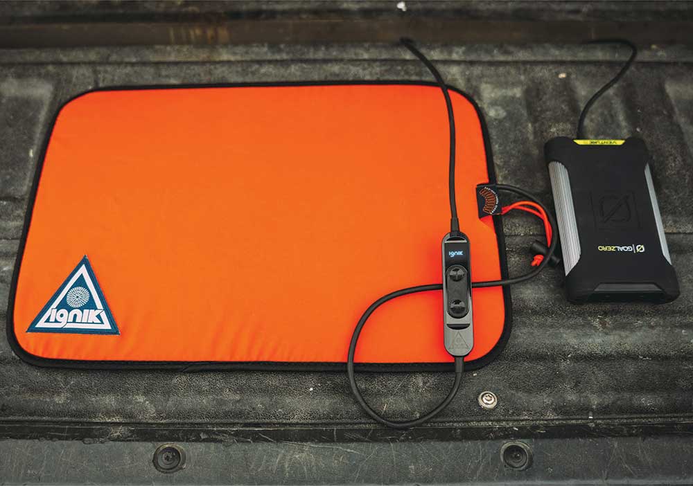 This orange pad attaches to a battery pack to make the tailgate it sits on warm.