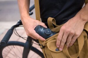 A man tucks the small cylindrical espresso maker into his bag.