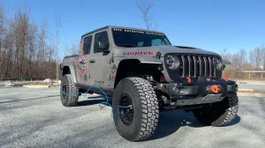 A 4x4 Jeep airs up all 4 tires at once with this blue compressor accessory.