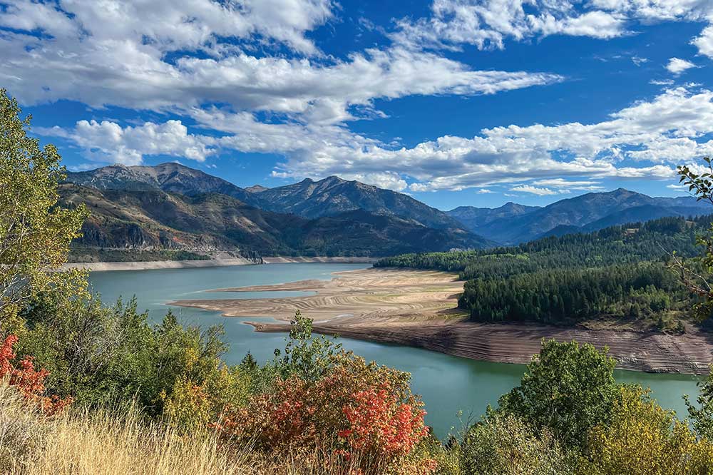 Mountains surround a reservoir with low blue water.