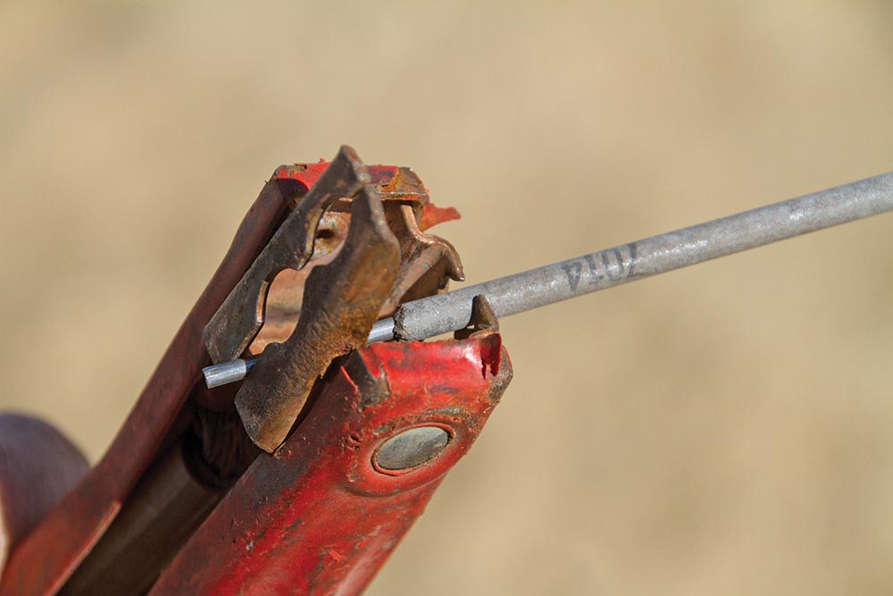 Jumper cables hold the electrode (welding rod) during a battery-welding trail fix.