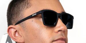 A guy's face, with black sunglasses on.