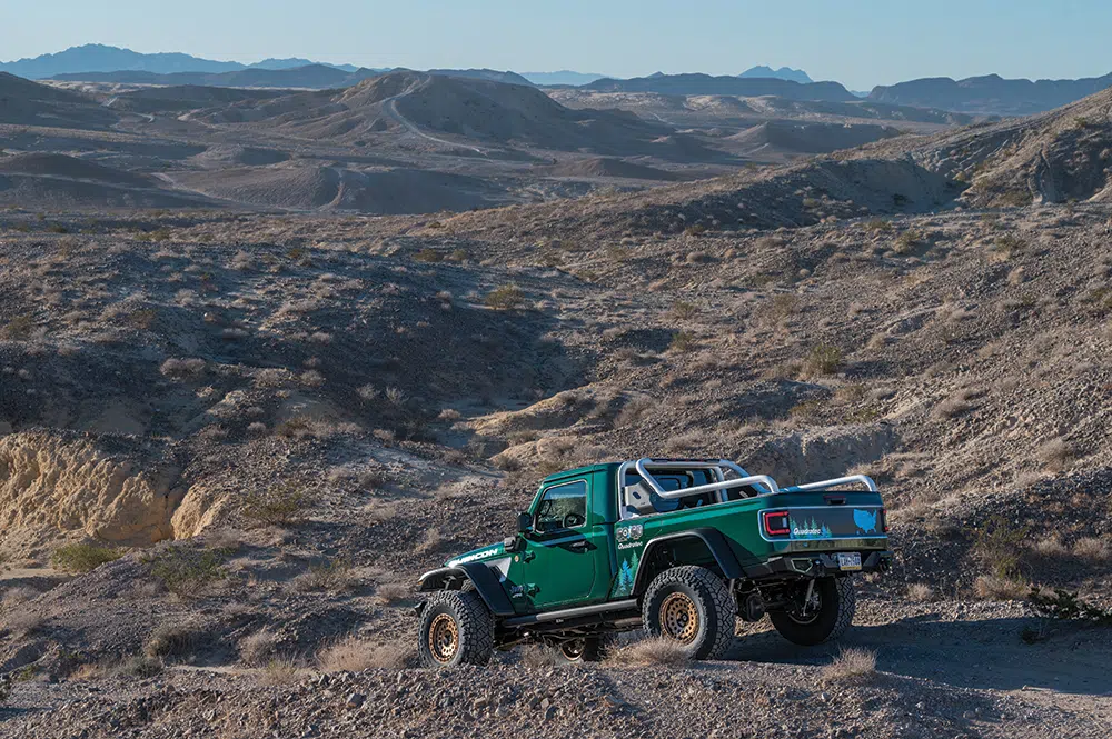 From a distance among the rid dirt hills, the green paint of the Jeep stands out.
