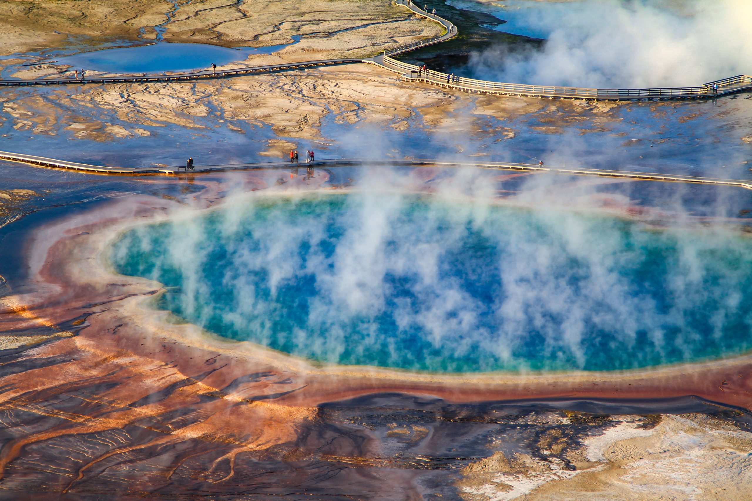 tourists walk along the grand prismatic spring of Yellowstone National Park