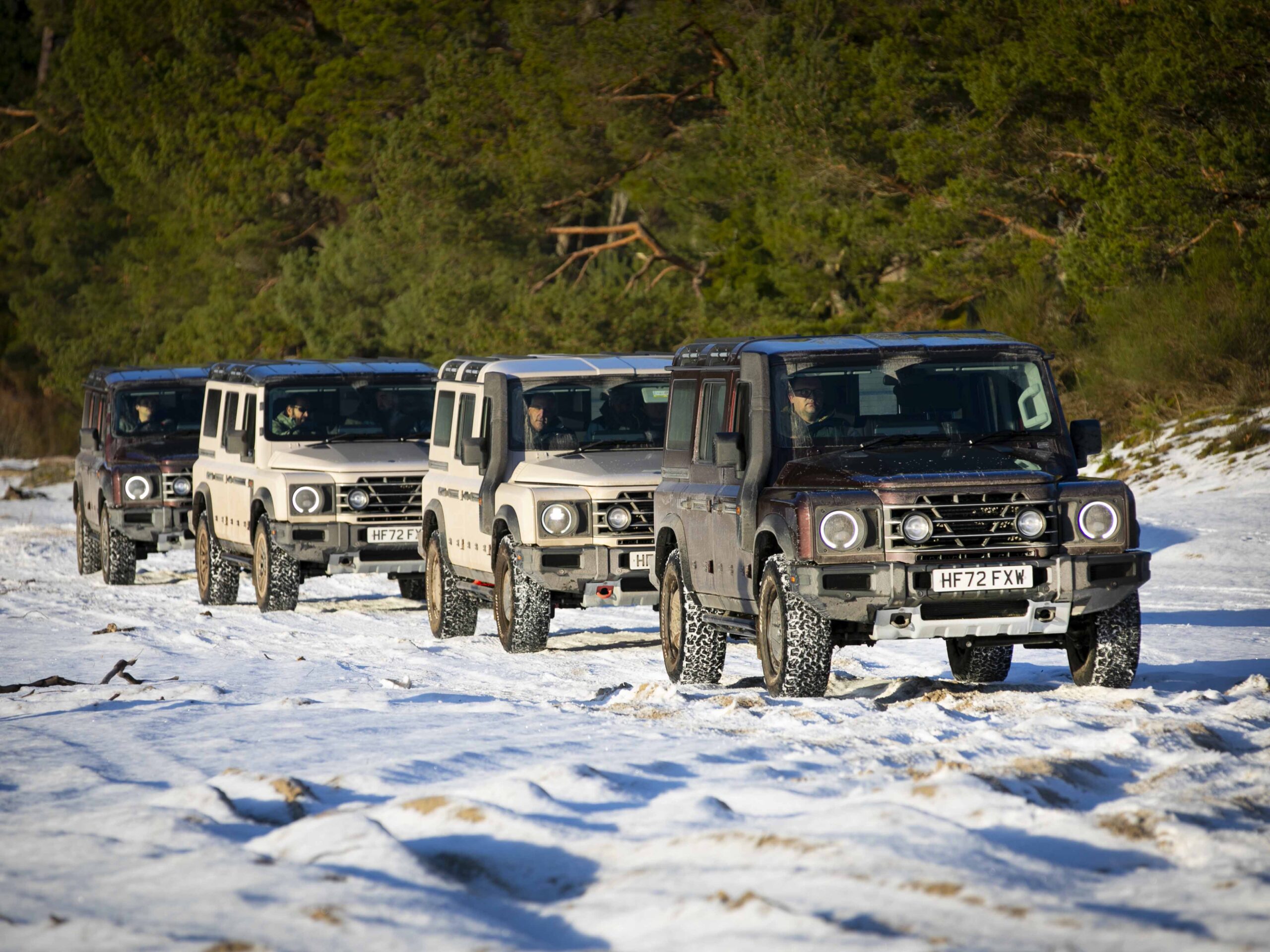 Four SUVs are lined up in the snow.