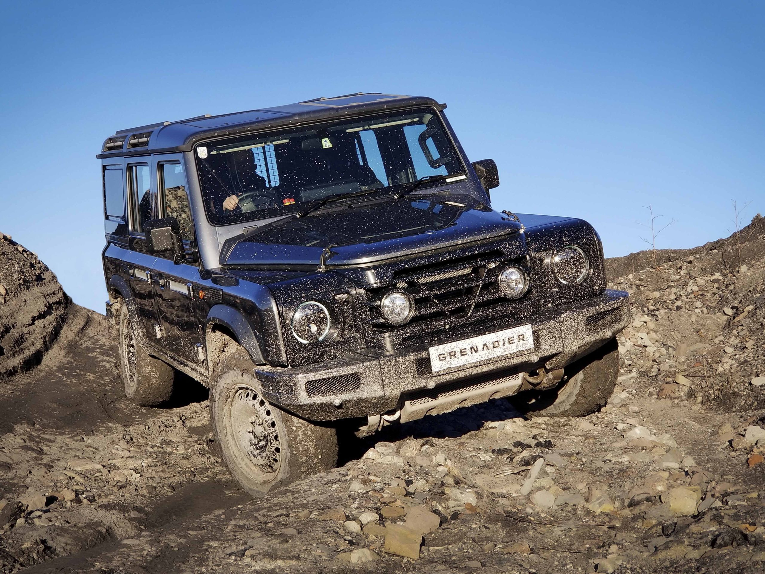 The 2B prototype INEOS Grenadier drives over a muddy trail.