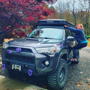 Lady Overlander Radio cohost Misti jumps up on the side of her 4Runner to secure her roof top tent