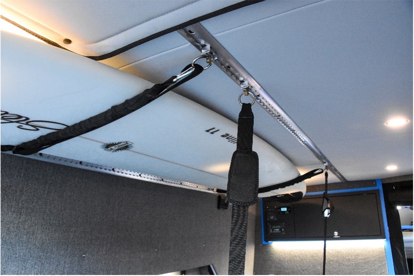 Straps used to secure a surfboard to roof of a van with Macs Tie Downs Versatie Track and Fittings.