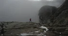 Person hikes over rocks at Pulpit Rock in Norway.