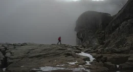 Person hikes over rocks at Pulpit Rock in Norway.