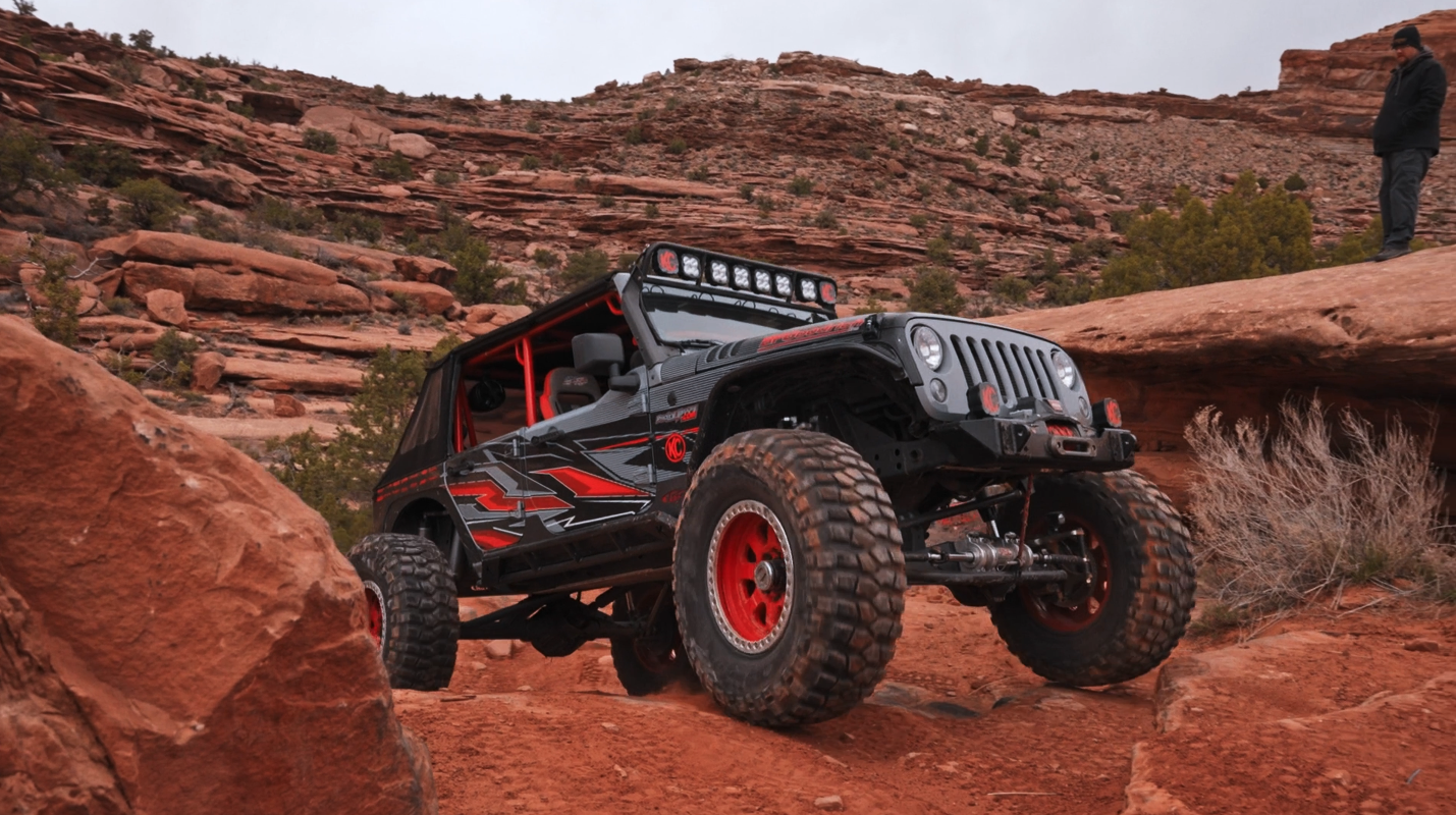 Jeep driving on red rocks in Moab, Utah.