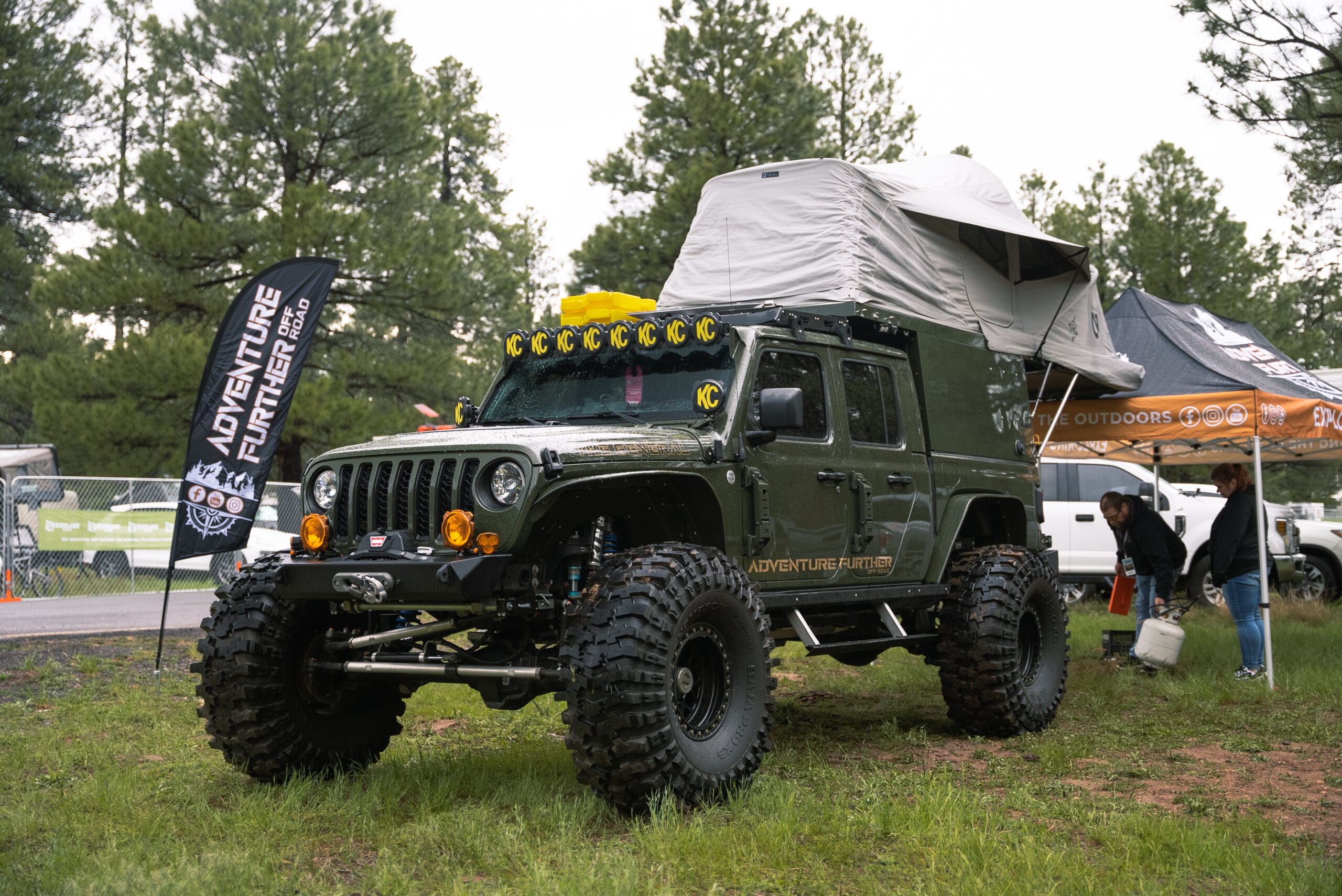 Green Jeep with roof top tent at Overland Expo West
