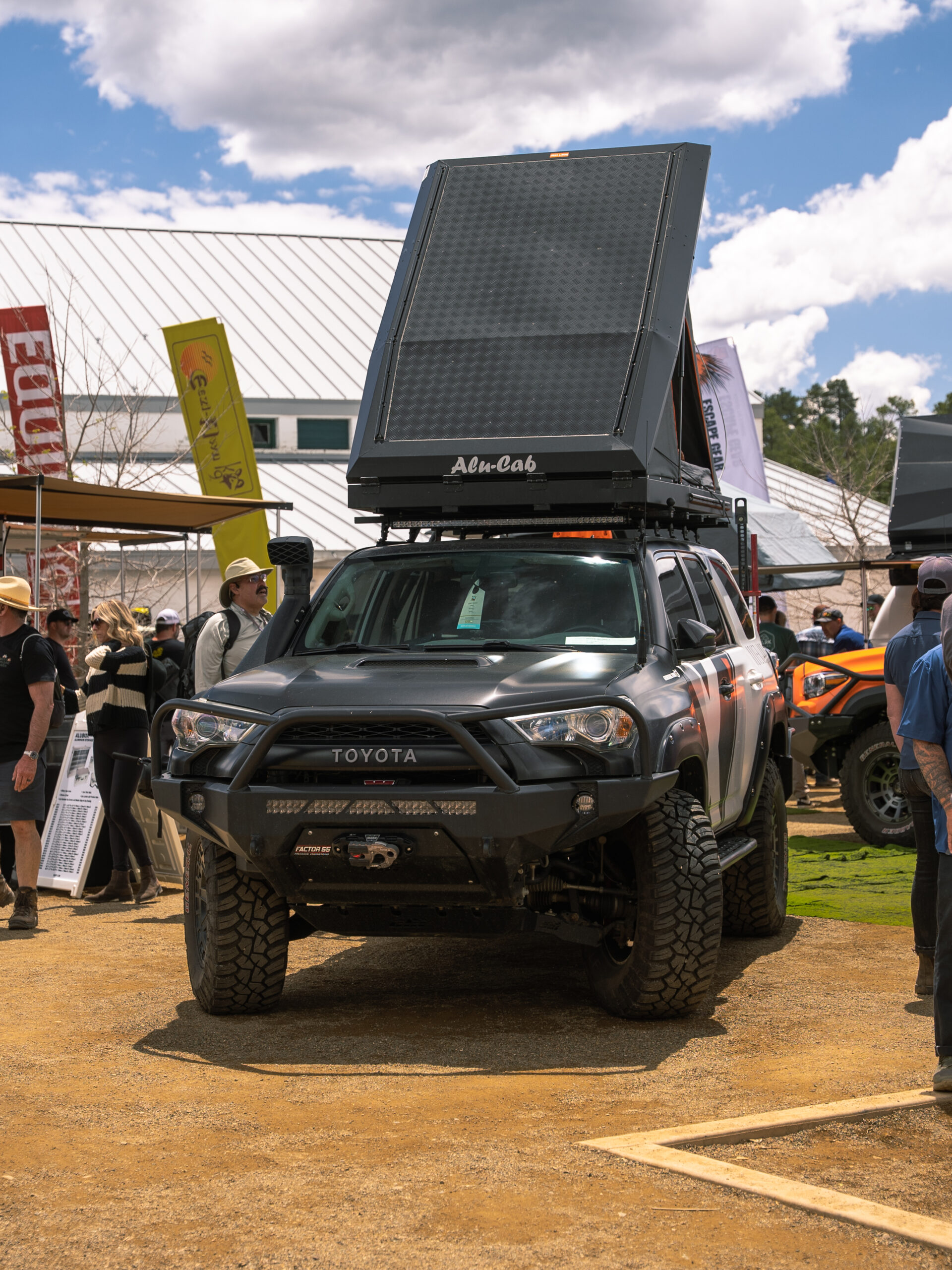 A black Tacoma with Alu-Cab pop-up tent at Overland Expo West.