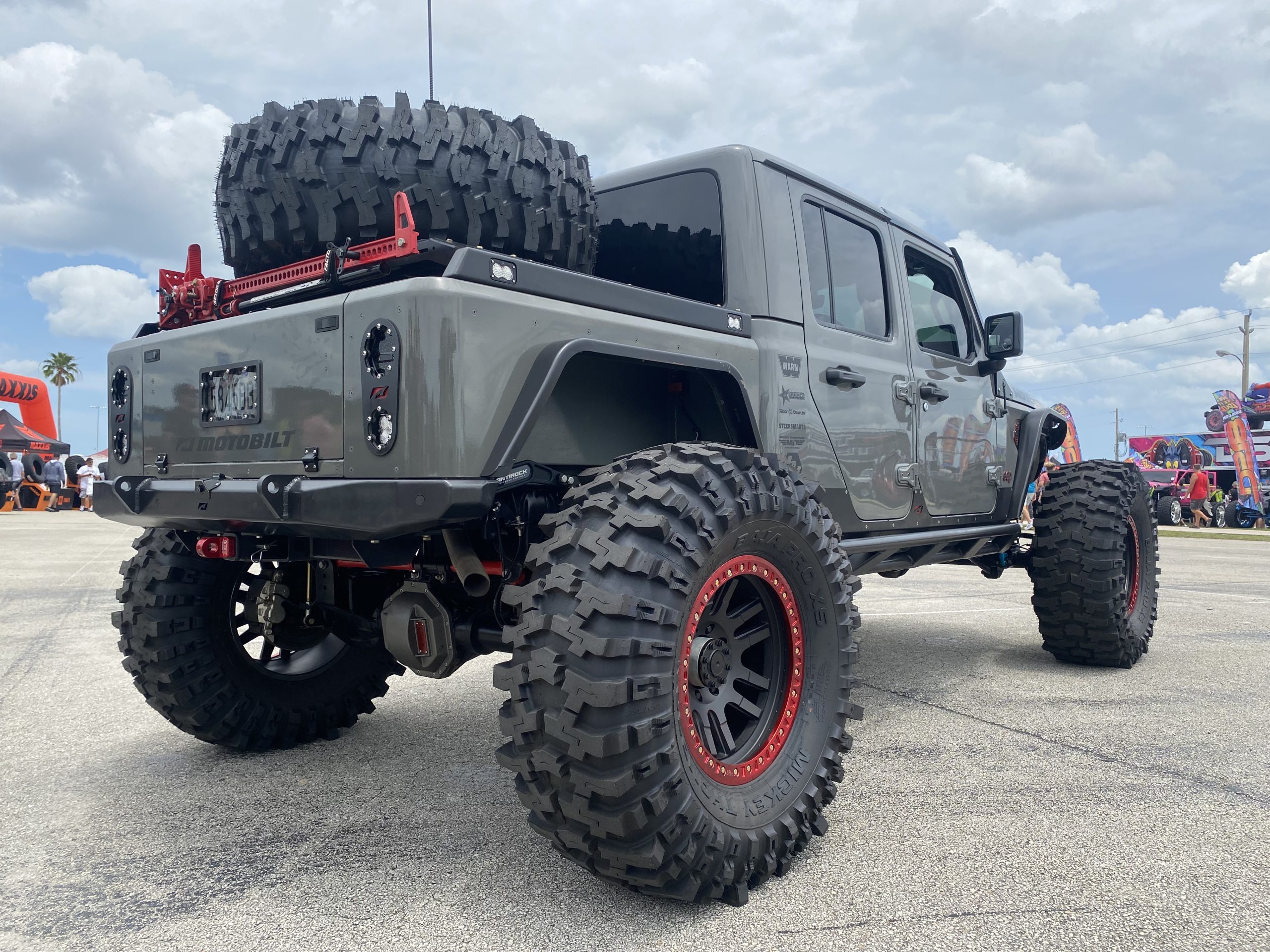 Gray Jeep Gladiator with spare tire mounted in bed.