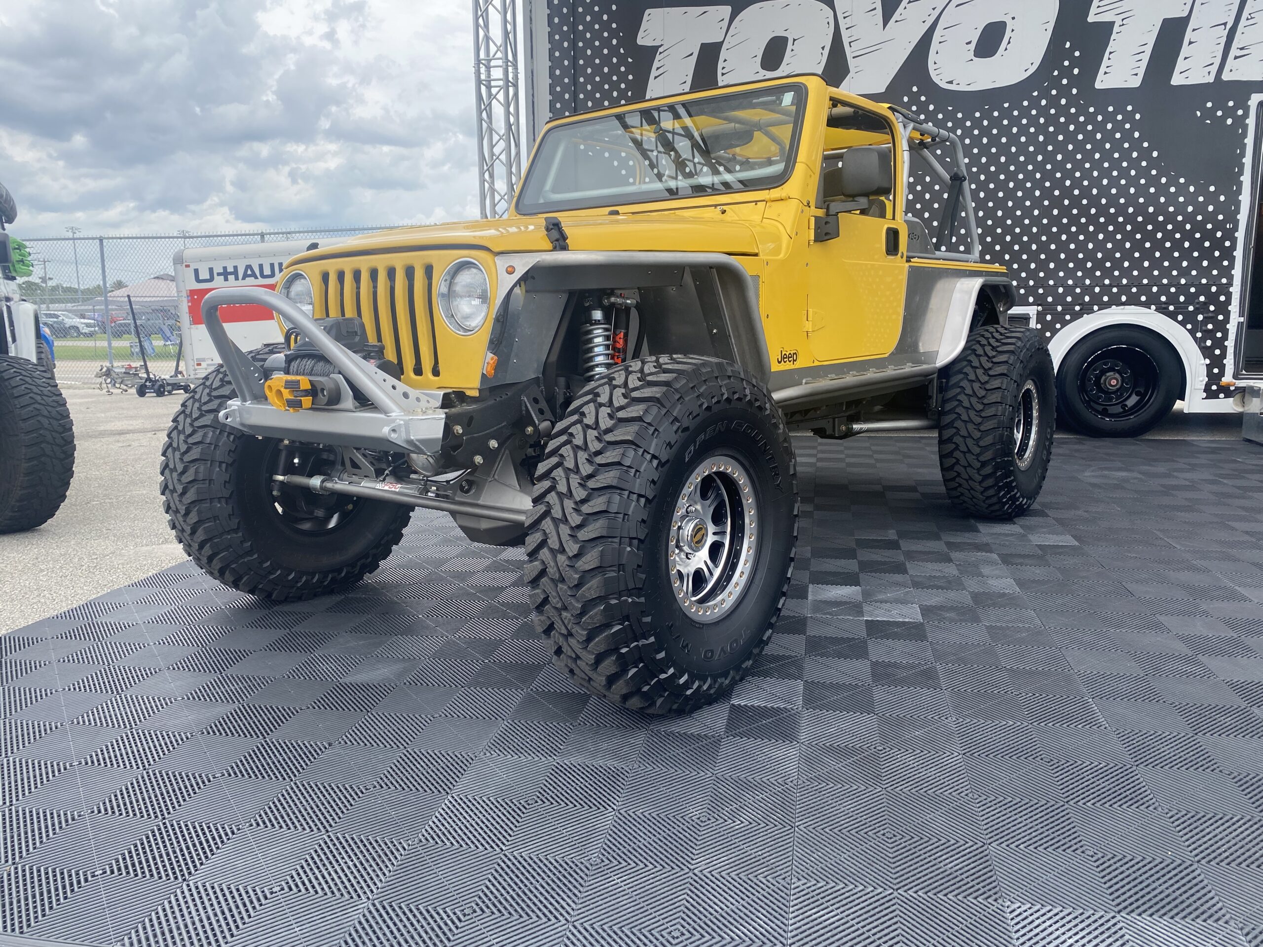 Yellow two door Jeep parked in Toyo Tires booth.