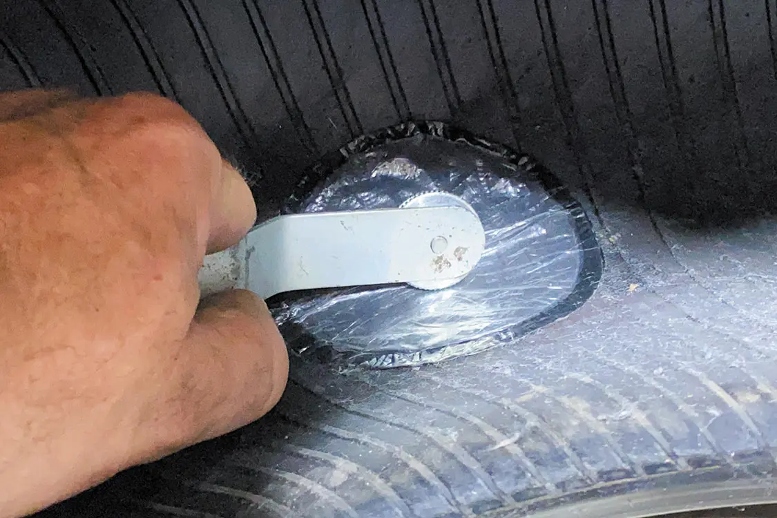 Put the patch in place and begin aggressively ‘stitching’ it with a roller tool
