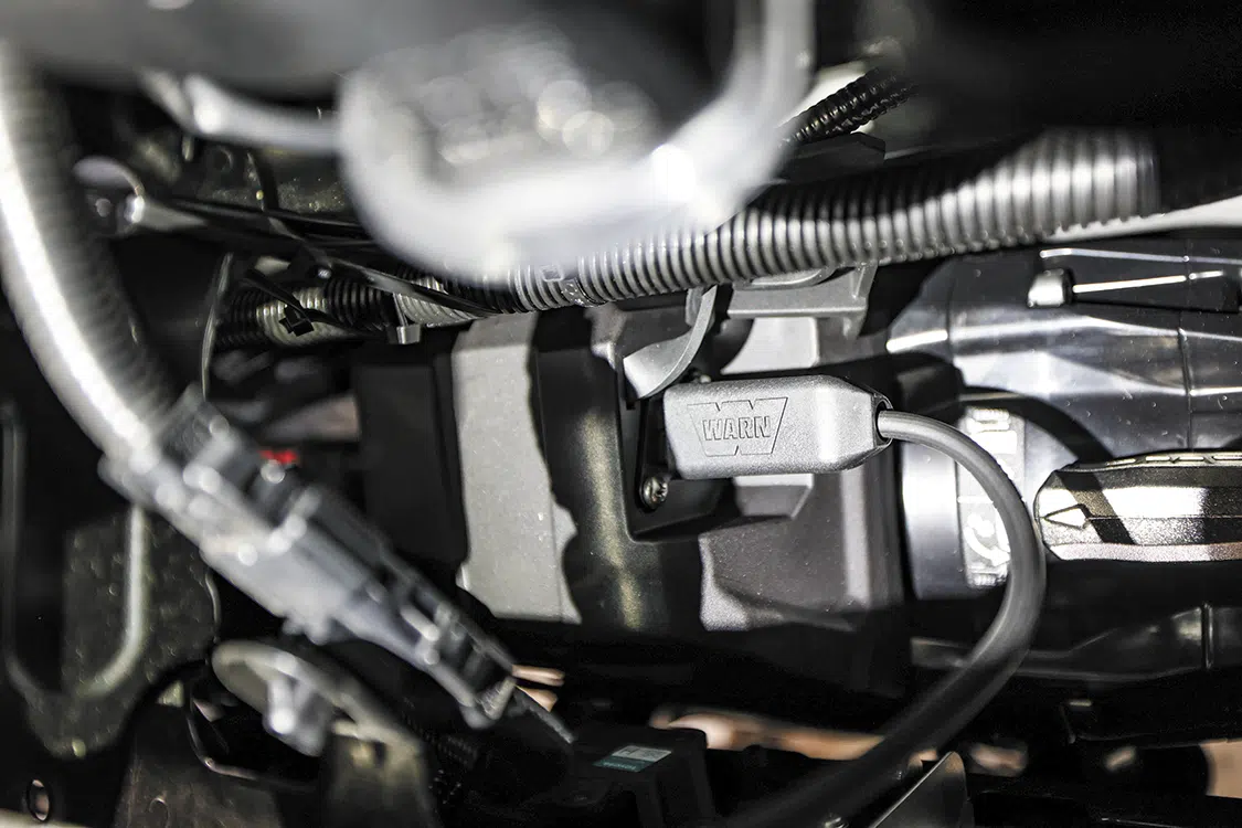 With the bumper securely mounted, we accessed the winch remote plug and free spool knob from behind the grille through the top opening